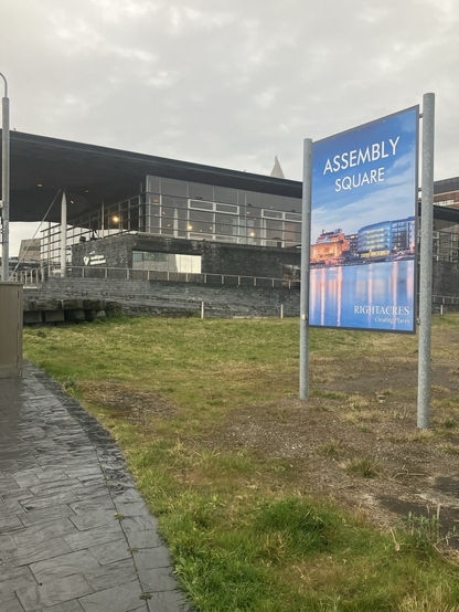Monoglot sign next to bilingual building