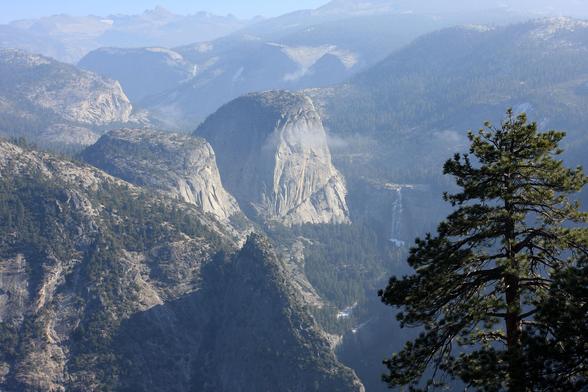 Liberty Cap and Nevada Fall  are at the center of Sierra mountains with scattered trees.