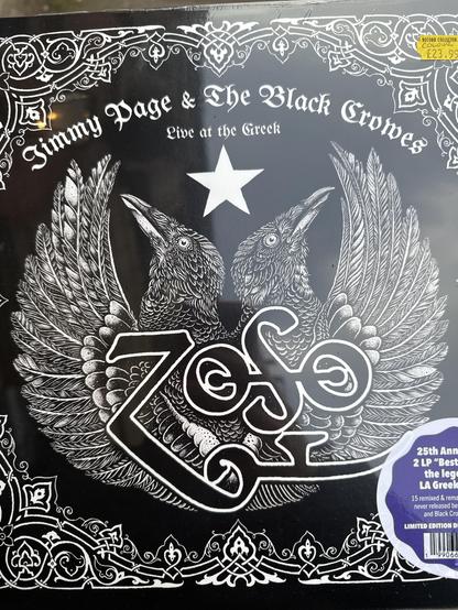The main cover of the album Jimmy Page and the Black Crowes. A Black and white cover either on the top the name on the band, right under it a white star and the black crowes logo, two crowes facing in two different directions. Over them the classic led zeppelin ZOSO logo