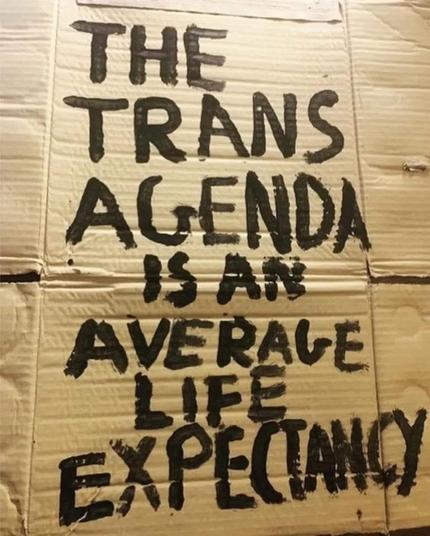 Cardboard sign reads:

The trans agenda is an average life expectancy