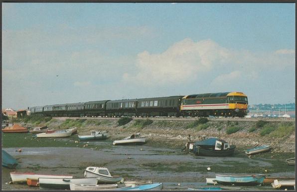Printed colour postcard showing a view of British Rail No 47620 Windsor Castle with the Royal Train passing Cockwood Harbour in Devon on its way to Torquay on 20 July 1988.
Published by Dawlish Warren Postcards, Exe Rail, No C10945X.
Postally unused.
Very good condition, with very slight corner bumps.
