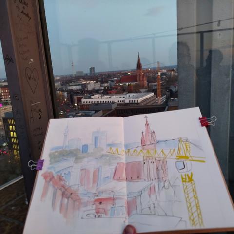 Skizzenbuch vor der Verglasung der Dachterrasse, darunter die City.