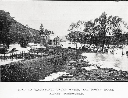 Black-and-white photo: Road to Taumarunui under water and power house almost surrounded. 1924. Description: Showing the road to Taumaranui under water and Taumaranui’s new hydro-electric works at Piriaka almost surrounded by flood waters from the Whanganui River on 5 April 1924. Citation: Supplement to the Auckland Weekly News, 17 April 1924, p. 36. Auckland Libraries Heritage Collections AWNS-19240417-36-01. https://kura.aucklandlibraries.govt.nz/digital/collection/photos/id/247053