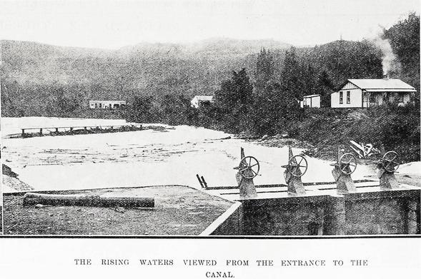 Black-and-white photo: The rising waters viewed from the entrance to the canal. 1924. Description: Rising flood waters on the Whanganui River viewed from the entrance to the canal at the hydro-electric power station at Piriaka, near Taumarunui. Citation: Supplement to the Auckland Weekly News, 17 April 1924, p. 36. Auckland Libraries Heritage Collections AWNS-19240417-36-02. https://kura.aucklandlibraries.govt.nz/digital/collection/photos/id/247054