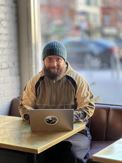 Johan sitting at a table working on his laptop