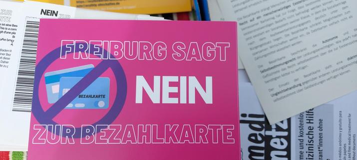 Rosafarbener Flyer mit der Aufschrift "Freiburg sagt NEIN zur Bezahlkarte"