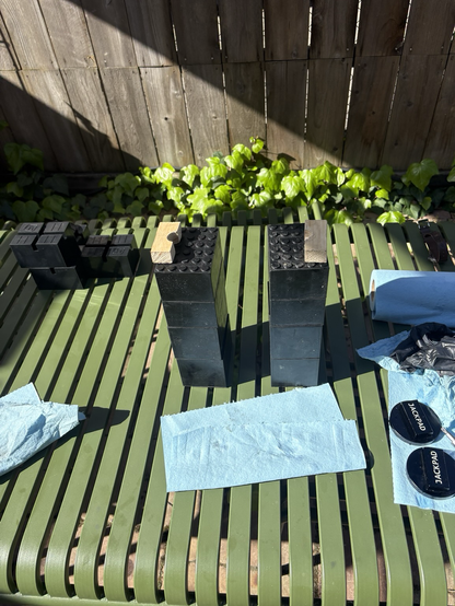 The two stacks of black rubber blocks I used to support the transmission for reassembly on my backyard patio table. On top of each stack of blocks is one of the wooden pieces I had made, intending to clamp them to the input shaft of the last clutch pack assemblies. Instead, I inverted the assemblies and rested the outer rim of the oil pump on the pieces of wood.