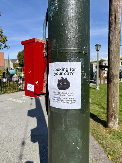 Photo of a paper flyer taped to a utility pole. The flyer depicts a simple cartoonish cat and reads, “Looking for your cat? He hopped on the train toward Ocean Beach! Maybe he got off at the next stop. Try checking the corner of Cole and Carl?”