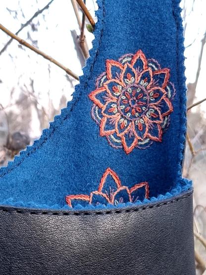 Close up on the lining at the belt, a smaller mandala flower in green and orange is show.