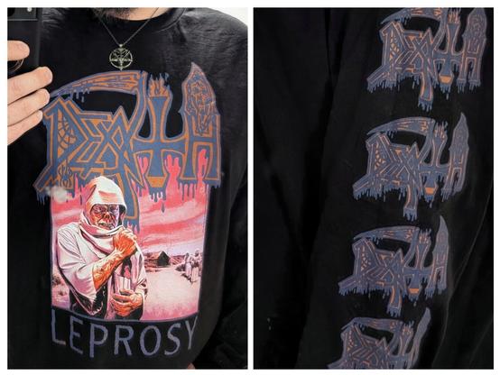 A bearded gentleman wearing a black longsleeve T-shirt. The shirt depicts the album artwork for Leprosy by the band Death. The logo for Death is blue and dark yellow.
