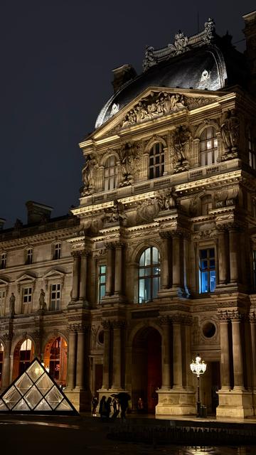 Ein Teil des Louvre bei Nacht. Links unten eine Glaspyramide, eines der Oberlichter.