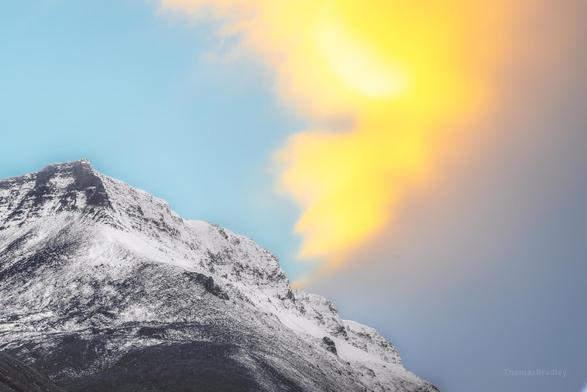 In the high Arctic realm of Svalbard, where the sun's touch is fleeting and the cold whispers secrets to those who listen, this image captures a moment where time itself seems to pause. The vast expanse of snow and ice stretches infinitely, merging with a sky that holds the soft hues of dawn or dusk—it's hard to tell which, as the polar day and night dance their endless waltz. Jagged mountain peaks punctuate the horizon, standing as silent sentinels to an untouched wilderness. The photograph invites the viewer into a world where solitude is profound, and the beauty lies in the delicate balance between harshness and serenity.