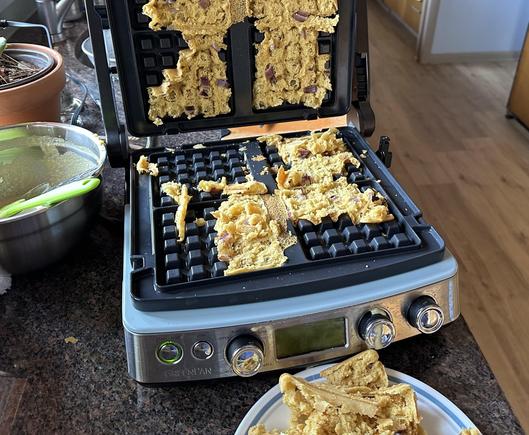 Chickpea waffles stuck to the top and bottom of an open waffle maker