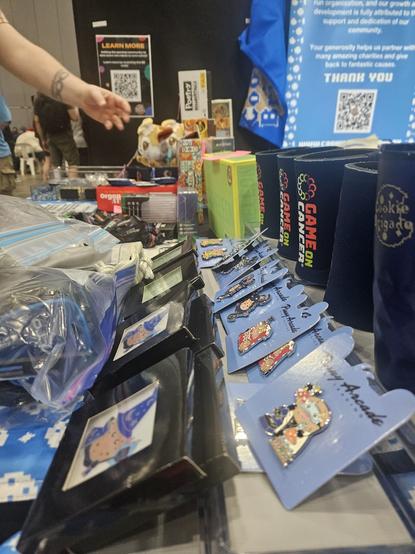 Picture of Pinny Arcade pins and other merch available at the booth