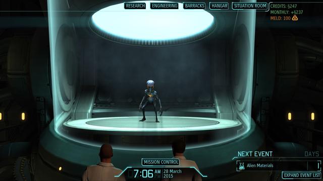 A 'sectoid' from the game XCOM stands in an isolation chamber as two scientists look on.