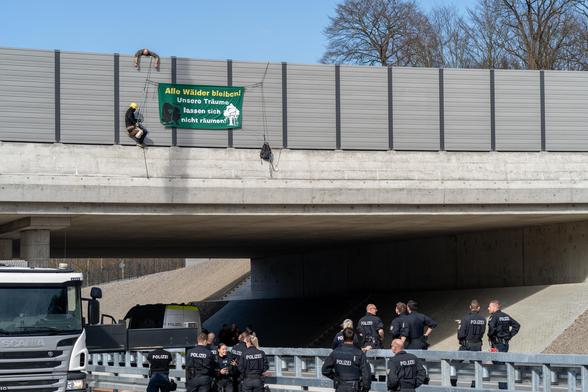 Abgeseilte Aktivistis über A49, darunter Cops