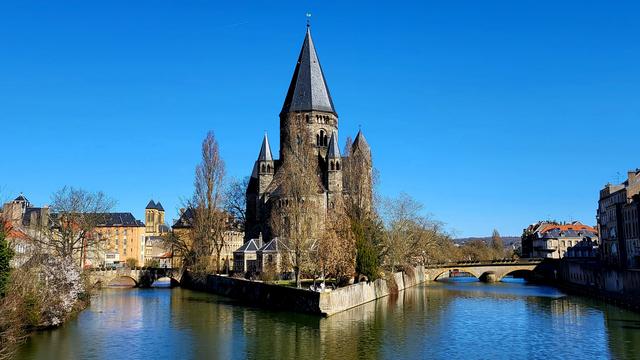 Le temple de Metz, sur son île. Elle fend le bras mort de la Moselle telle la proue d'un paquebot. Le centre ville sur la droite. Le lycée Fabert et sa Sainte Constance sur la gauche. Un pont de chaque côté.