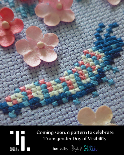 An extreme closeup of a cross stitch showing a catepillar in trans pride colors. Trans Lifeline logo.  Coming soon, a pattern to celebrate Transgender Day of Visibility. Hosted by BAD Stitch.
