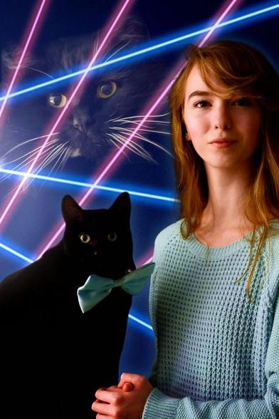 Professional department store-style portrait photograph of a lady with her cat wearing a bowtie that matches her knitted sweater. The background shows fancy neon pink and blue lines with the kitty's face superimposed above. THIS is how you do a family portrait!