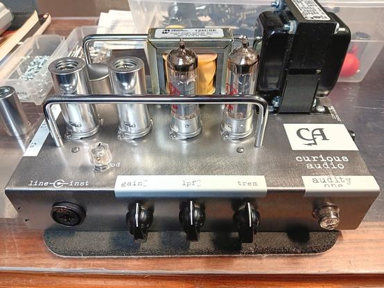 Audity One Recording Amplifier head with clear steel chassis, white UV printed graphics, three black knobs, chrome handles, four vacuum tubes, and two transformers.