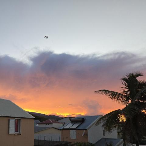 Le ciel un peu après l'aube, les premières lueurs du soleil se heurtent à une masse nuageuse tandis que les contours des nuages plus bas derrière les colines, commencent à s'embraser de lumière orangée, donnant l'impression qu'il y a un feu derrière les colines avec la fumée montante des nuages