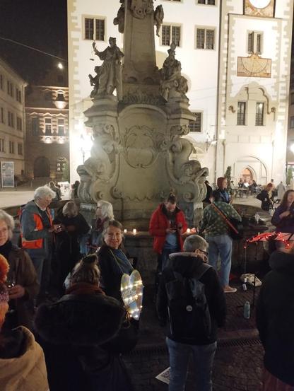 Foto von weiter oben aus der Menschenmenge in Richtung des Brunnens. Ein Schild der Omas for Future ist erkennbar.