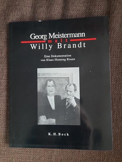 Buchcover auf Stoffunterlage, zeigt ein Schwarzweiß Foto von Brandt neben seinem Portrait