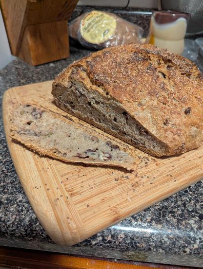 A slice into bread 15B. Lots of aging means not the biggest rise. You can see the pecans and olives I put inside of it. It leaves behind an interesting sour almost bitter aftertaste