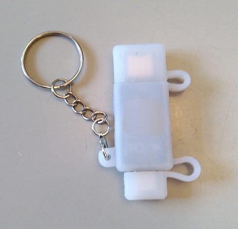 The Token2 key wearing a white silicon case with caps that protect the USB-A and USB-C connectors and that are attached to the rest of the case with a silicon hinge. The case itself has a metal keyring.