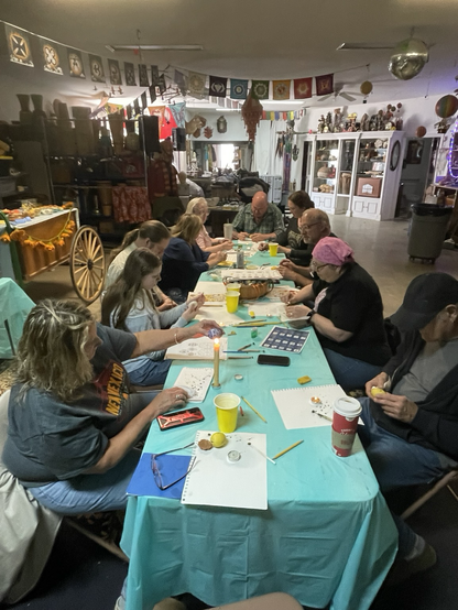 A group of people writing pysanky for Ukraine.