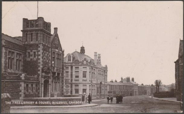 Sepia real photographic postcard showing a view of the Free Library and Council Buildings at Camborne in Cornwall.

The Meeksown Series, No 2056.

Postally used on 9 August 1912 with double circle Camborne cancellation on green halfpenny stamp and sent to Miss L. Rickard, c/o J Holman Esq, Carrack Gladden, Carbis Bay.

Good condition, with very slight corner bumps, but small crease to top left corner and two very light arc bends to right centre.