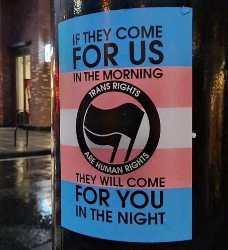 Bildbeschreibung

Aufkleber an Laterne mit dem Posttext in trans Farben auf welchem in schwarz steht IF THEY COME FOR US
IN THE MORNING
THEY WILL COME FOR YOU 
IN THE NIGHT

in der Mitte ein Kreis mit zwei schwarzen Flaggen umrandet von einem Schwarzen Kreis in welchem "Trans rights are Human rights" steht