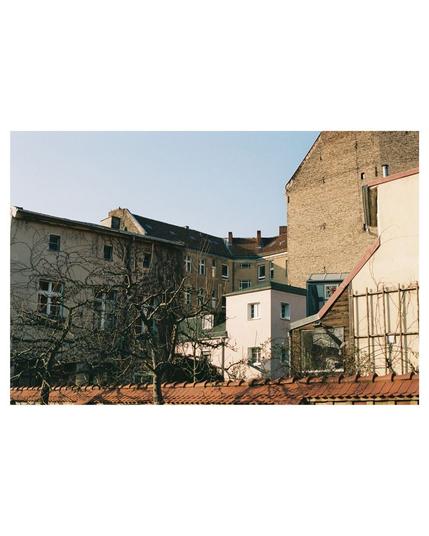 backyary with differently shaped buildings, all falling into their place and are shaped by strong sun light und shadows