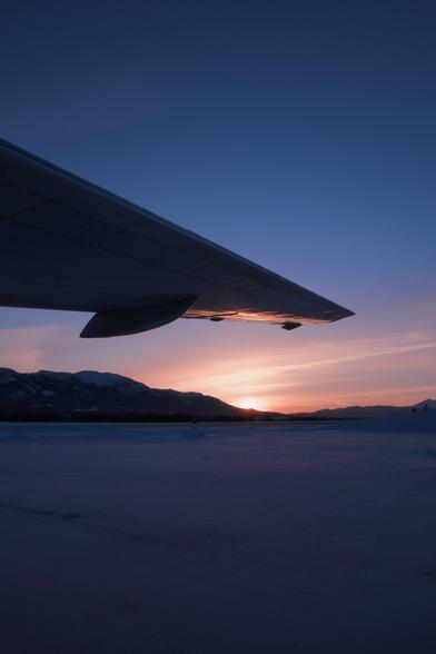The sun is just beginning to creep past the edge of Grey Mountain in Whitehorse. We’re looking across the Erik Nielsen Whitehorse International Airport from under the port side wing of C-GANV, a Boeing 737-200 Combi that was operated by Air North, Yukon’s Airline.