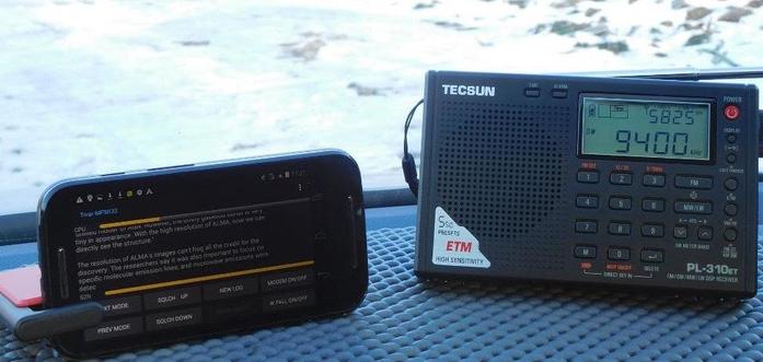 A photo giving an example of receiving text via shortwave. An Android device with the necessary app sits next to a portable shortwave radio. No patch cord.