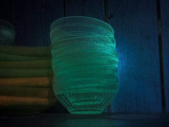 Stack of glass bowls that are weakly glowing yellow.