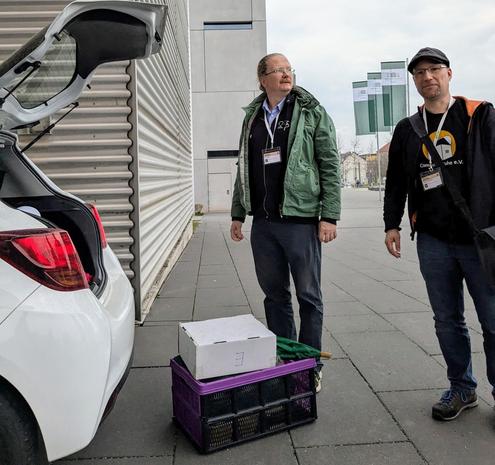 Bild zeigt Tim und Marco beim Verladen des Computertruhequipments zum Schluss der Linuxtage vor der TU Chemnitz.