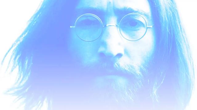 A portrait in pale blue/lilac tones of a bearded John Lennon wearing long hair and trademark round glasses, staring fearlessly into the camera lens. Image: Sydney Opera House, Australia.