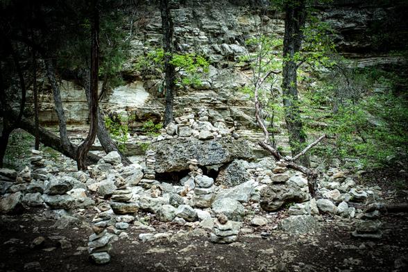 Rock formations and trees in a forest setting.