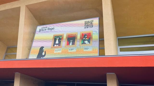 Foto: Über dem Eingang Digitaldisplay zu Linux-Tage mit Pinguinen in verschiedenen Posen.