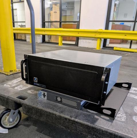 Eva's Talos II system, sitting on a storage push-cart, resting atop a 48 port switch for fun and ... "ESD protection?"... in transit back to its proper home.