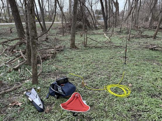 My equipment in a muddy woods. Radio on my backpack, folding camp chair, coax to my vertical whip antenna.