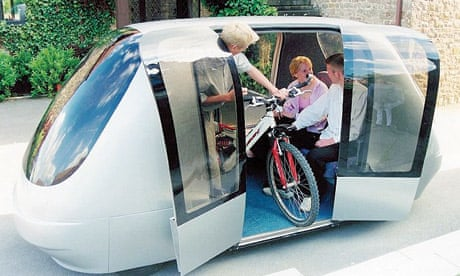 another picture of a PRT car where someone is taking a bmx bike off the car, and you can see two people sitting inside.