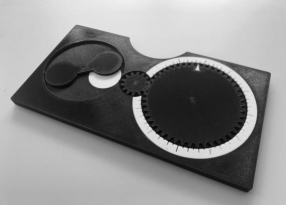 Black and white, smartphone-sized mechanical lunar phase calculator with a circular calendar dial and a moon phase display.