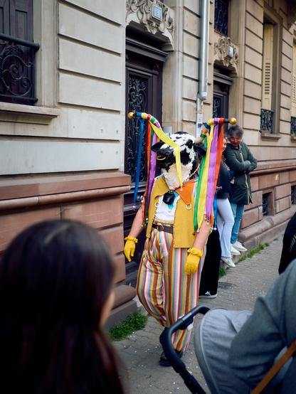 Un homme avec une tête de vache avec des rubans de couleur sur ses cornes