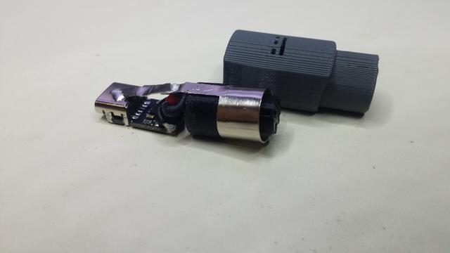 A tiny USB-C PowerDelivery decoy board wired to some round shielded connector, with the grey housing on the side.