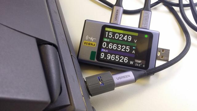 The device plugged into a PowerBook 520c, with a power meter indicating 15V and about 10W.