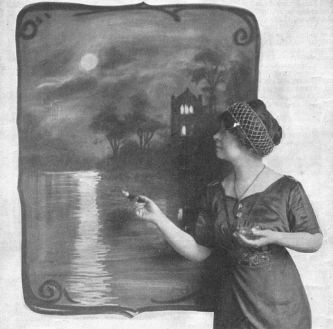 Evelyn Bargelt, photographed in profile with one of her live paintings; a white woman wearing her dark hair in a wrap, and a dark dress; she is holding a paintbrush in her right hand