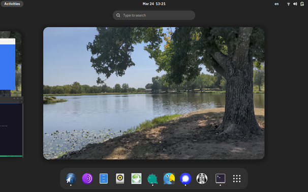 GNOME Overview on Trisquel. Background features a lake. Apps include Abrowser, Tor Browser, Rhythmbox, Icedove, Snikket Web Demo, Signal, and Mumble.