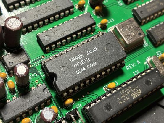 A Yamaha YM3812, also known as OPL2, on a green PCB. The chip is in a wide DIP24 package.